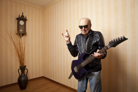 cool fashion elder man with electric guitarの写真素材