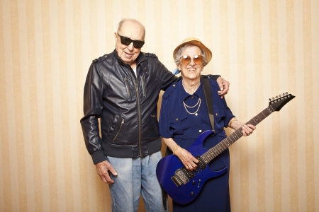 cool fashion elder couple with electric guitarの写真素材