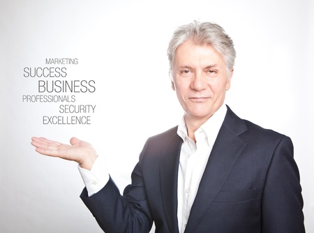 Happy senior businessman with hand gesture showing copyspace on white backgroundの写真素材