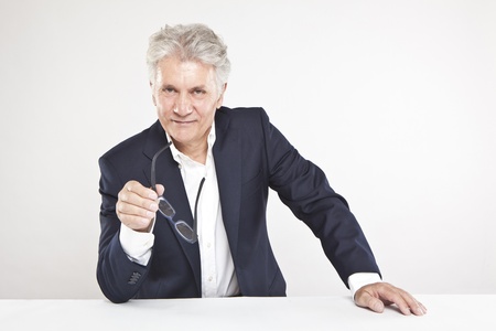 Successful mature businessman looking at camera  at work in officeの写真素材