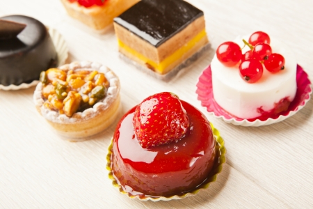 Different sort of beautiful pastry, small colorful sweet cakesの写真素材