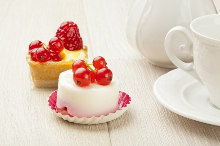 fruit pastry little cake with tea cup on white wooden tableの写真素材