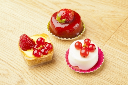 small beautiful red fruit pastry on wooden tableの写真素材