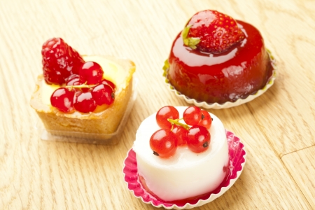 small beautiful red fruit pastry on wooden tableの写真素材