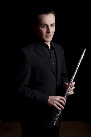 professional flutist musician playing flute on black backgroundの写真素材