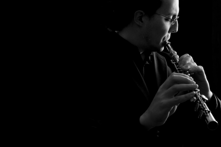 professional flutist musician playing flute on black backgroundの写真素材