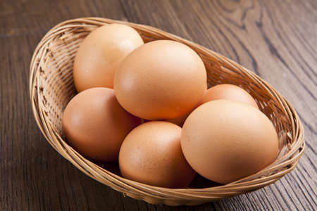 eggs in a bascket on wooden tableの写真素材