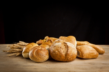assortment of fresh baked bread on wood tableの写真素材