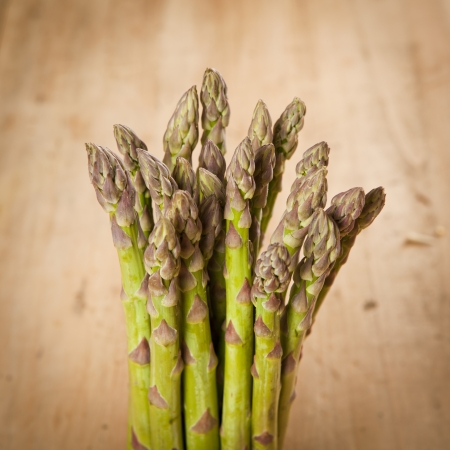 Bunch of fresh green asparagus on wooden backgroundの写真素材