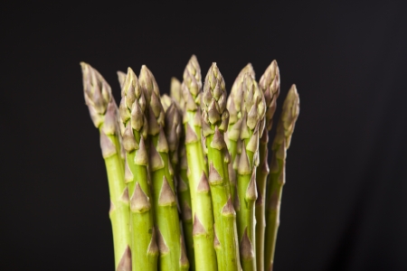 Bunch of fresh green asparagus on black backgroundの写真素材