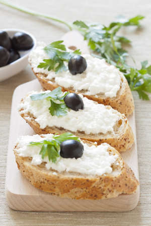 Crostini with cottage cheese, parsley and oliveの写真素材