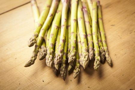 Bunch of fresh green asparagus on wooden backgroundの写真素材