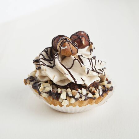 Closeup muffin with vanilla cream and hazelnutsの写真素材