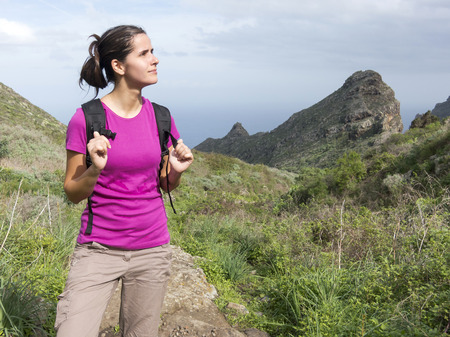 woman hiker with backpack walking and smiling on a country trailの写真素材