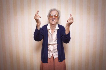 cool elder lady making middle finger signの写真素材