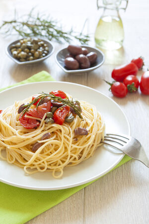 italian spaghetti pasta with cherry tomatoes, olives, capers and rosmary, mediterrean food, vegan recipeの写真素材