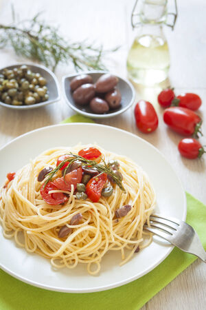 italian spaghetti pasta with cherry tomatoes, olives, capers and rosmary, mediterrean food, vegan recipeの写真素材