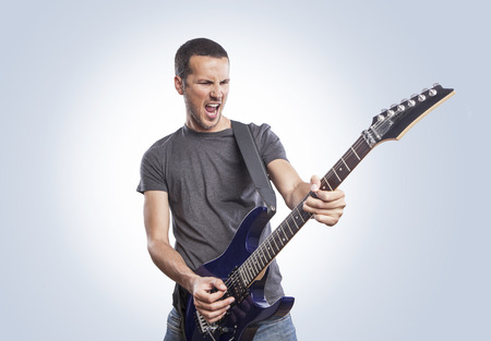 handsome young man playing electric guitarの写真素材