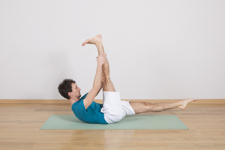 man practicing pilates indoor, return to life sequence, 34 exerciseの写真素材