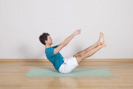 man practicing pilates indoor, return to life sequence, 34 exerciseの写真素材