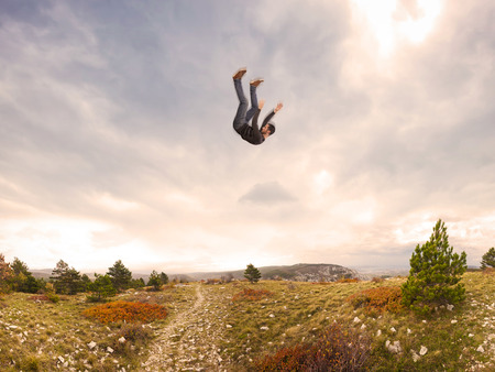 man falling down from the sky in autumnal landscapeの写真素材