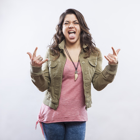 Young woman doing rock horn hand gestureの写真素材
