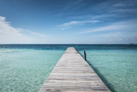 wooden dock into blue tropical sea in Isla Mujeres, Yucatan Mexicoの写真素材