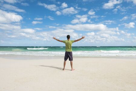 young man enjoying freedom on a tropical beachの写真素材