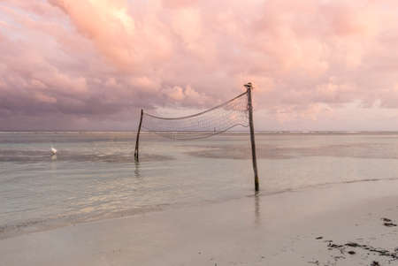 beach volley net on the sea at sunsetの写真素材
