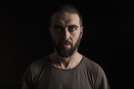 portrait of a handsome bearded man on dark backgroundの写真素材