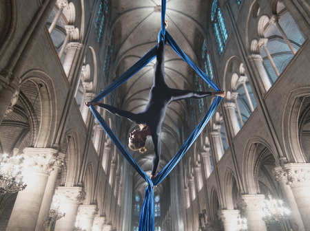 beautiful woman dancing with aerial silk in a cathedral interiorの写真素材