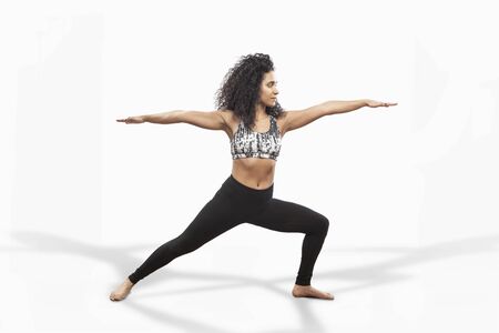 Beautiful mixed race woman doing yoga warrior pose