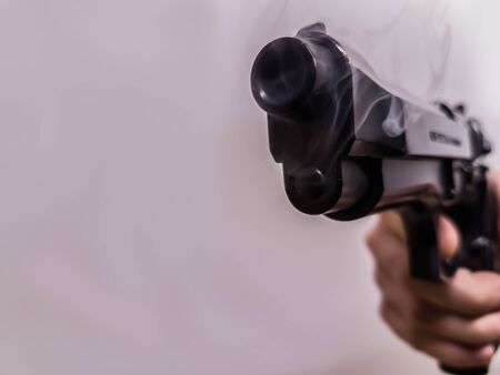 A gun with a smoking barrel after he fired a shotの写真素材