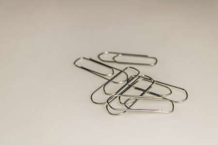 a pile of metallic staples, silver colored and placed on a white surface