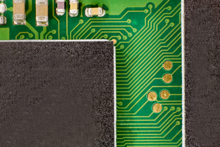 Close-up photo of a green electrical circuit connecting two black electronic components via BUS type...