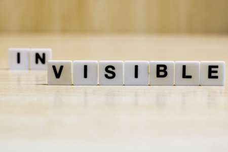 A row of small white plastic tiles, containing the letters forming the word visible, to represents the concept of seeing what was previously invisible.の写真素材