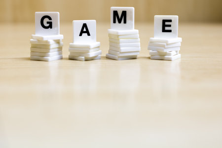 A row of small white plastic tiles, containing the letters forming the word game, to represents the concept of the game.の写真素材