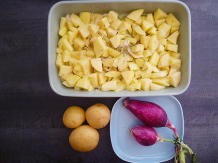 Italian onions on blue ceramic plate, potatoes and sliced ??potatoes mockupの写真素材