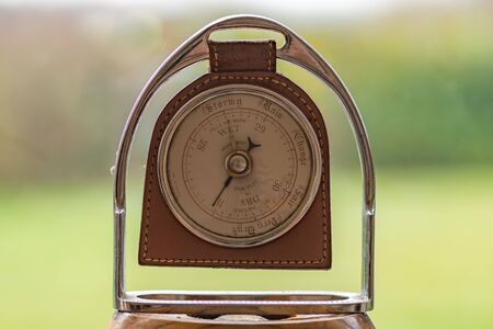 Close up of an old antique barometer made out of an old horses stirrup  indicating high pressure and fine weather.の写真素材