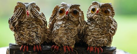 Close up of three ornamental owls depicting the proverb.See no evil.Hear no evil.Speak no evil.の写真素材