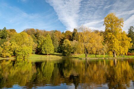 View of the autumn colours around the lake at Stourhead gardens in Wiltshire.