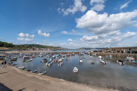 Landscape photo of boats floating in the harbour at Lyme Regis in Dorsetの写真素材