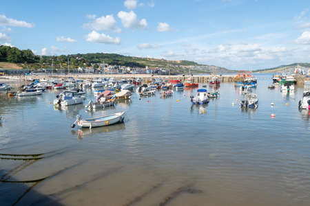 Landscape photo of boats floating in the harbour at Lyme Regis in Dorset