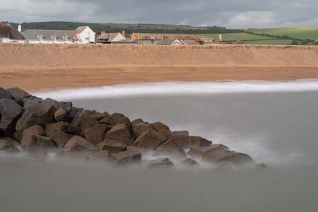 Long exposure of the tide washing up against the rocks on the East Beach at West Bay in Dorsetの写真素材