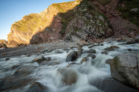 Long exposure of the river Heddon flowing onto the beach at Heddons Mouth in Exmoorの写真素材