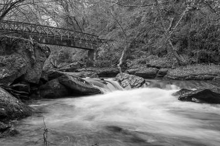Long exposure of the East Lyn river flowing under a bridge at Watersmeet in Exmoor National Parkの写真素材