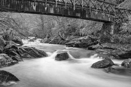 Long exposure of the East Lyn river flowing under a bridge at Watersmeet in Exmoor National Parkの写真素材