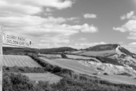 Close up of a footpath sign pointing to Golden Cap mountain on the Jurassic Coast in Dorsetの写真素材