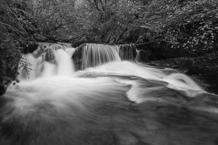 Black and white photo of a waterfall on the Hoar Oak Water river at Watersmmet in Exmoor National...