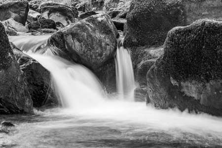 Long exposure of a waterfall on the East Lyn river flowing through the woods at Watersmeet in Exmoor National Parkの写真素材